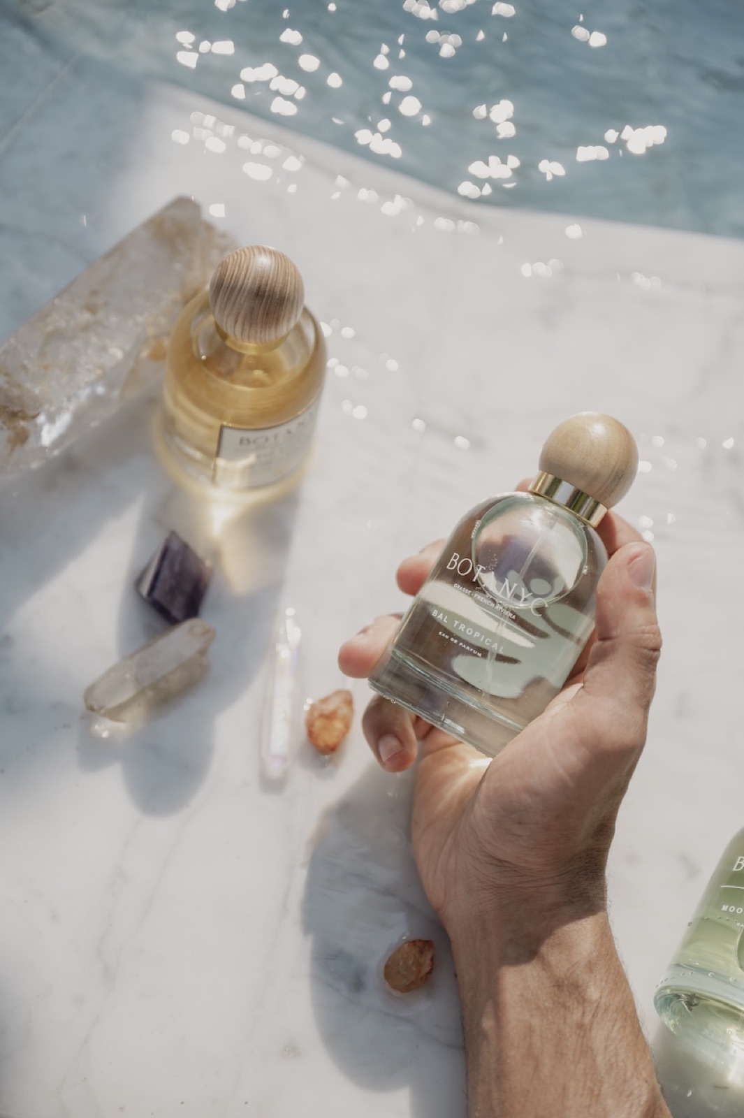 Perfume bottles styled with crystals on marble