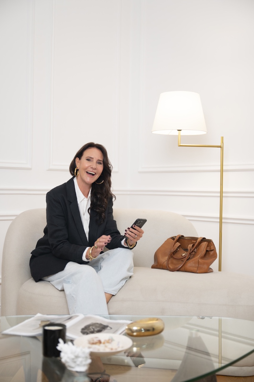 Founder laughing on a cream sofa