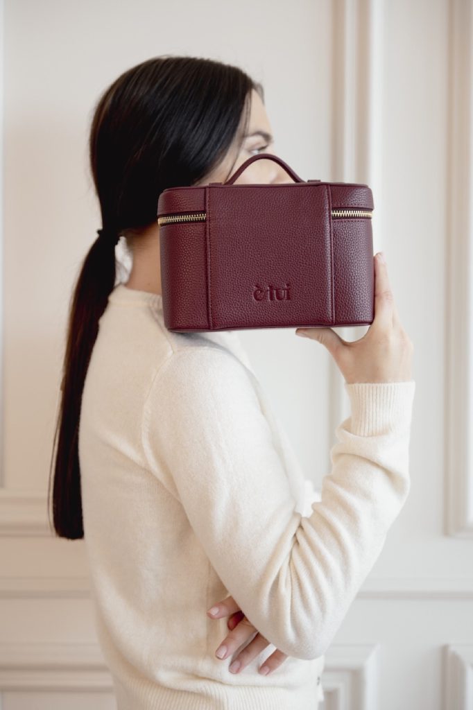 Model holding a burgundy vanity case