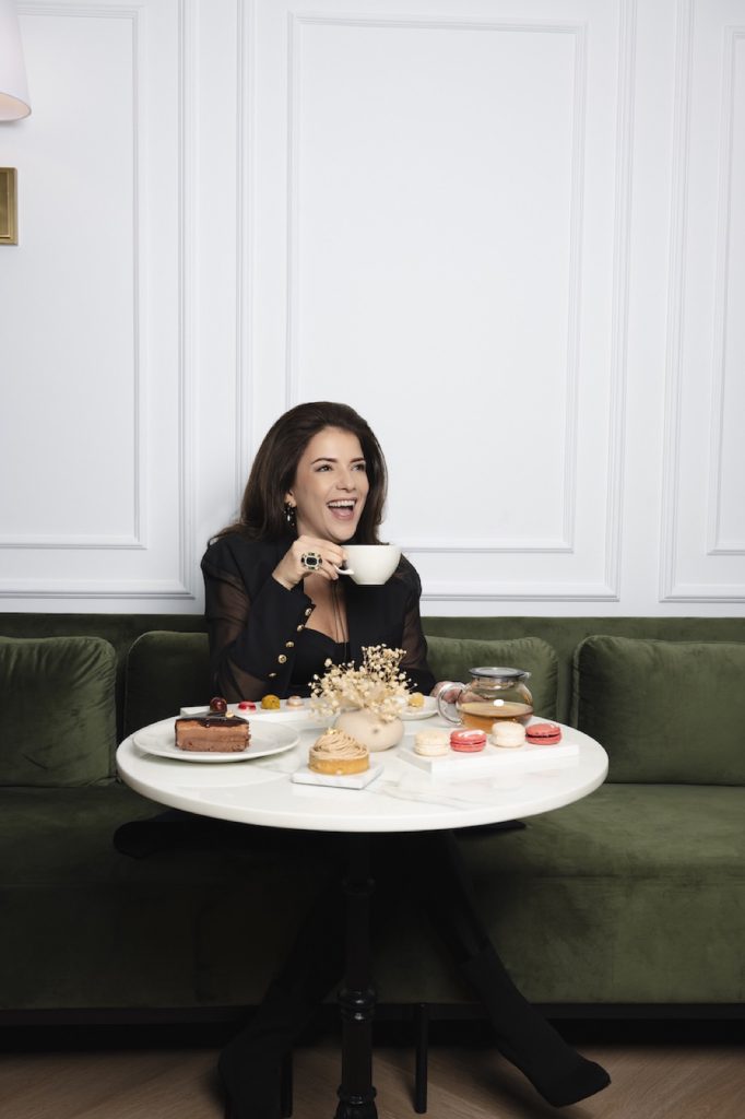Guest enjoying afternoon tea on a green velvet sofa