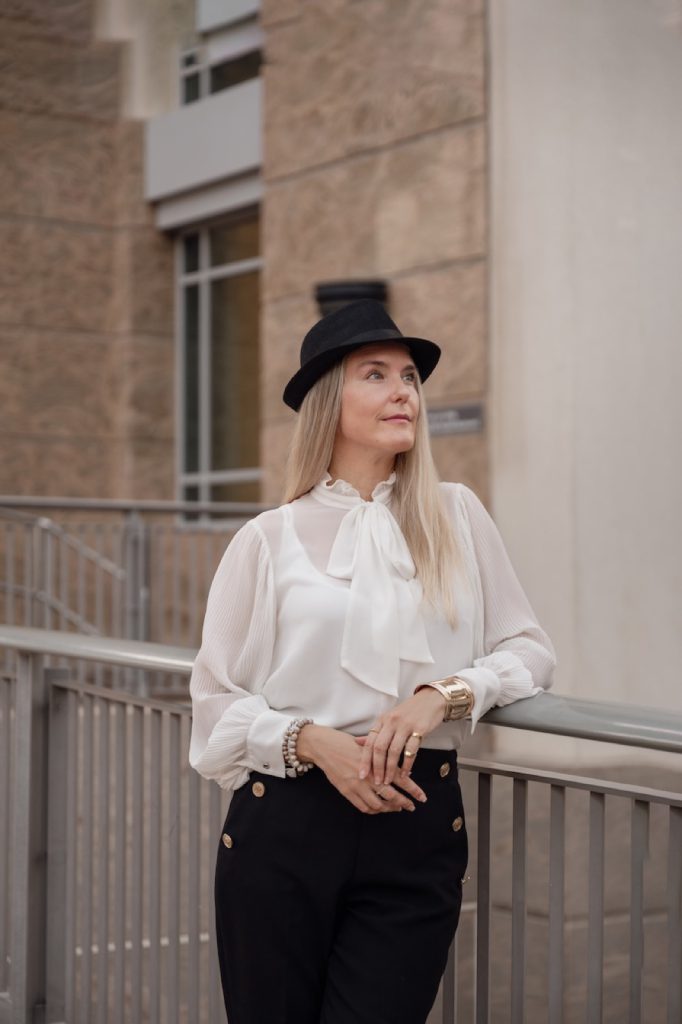 Founder in a hat on a city balcony