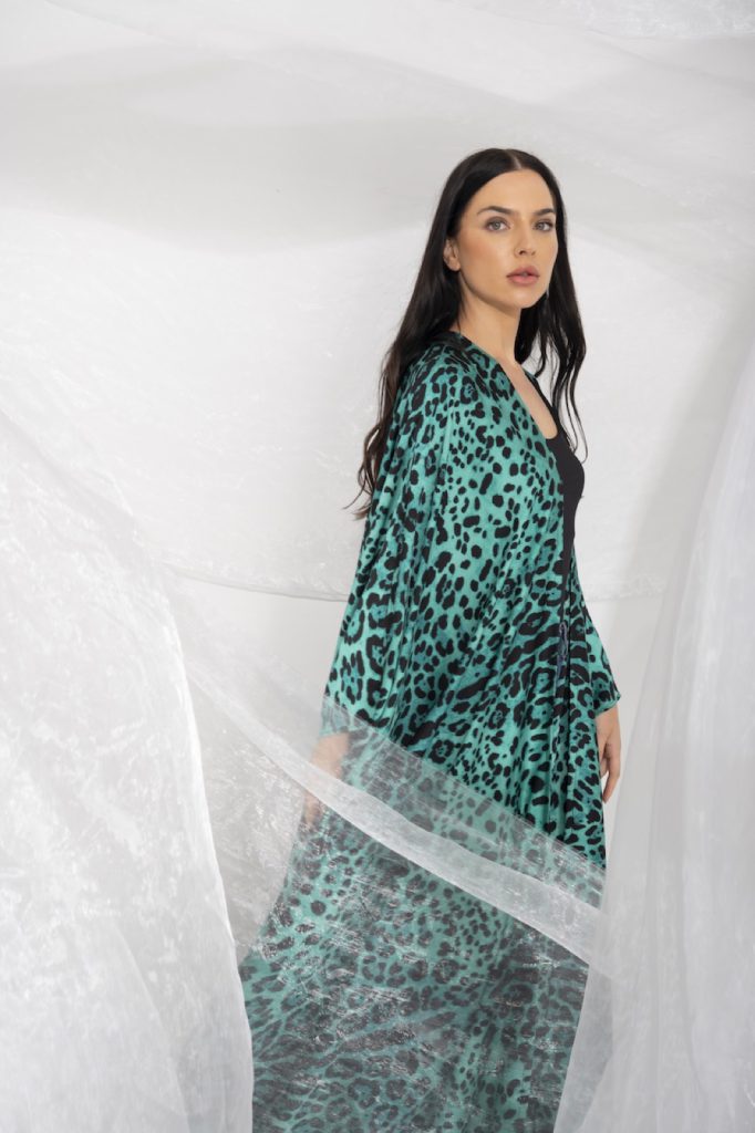 Model in a leopard print kaftan among sheer fabric