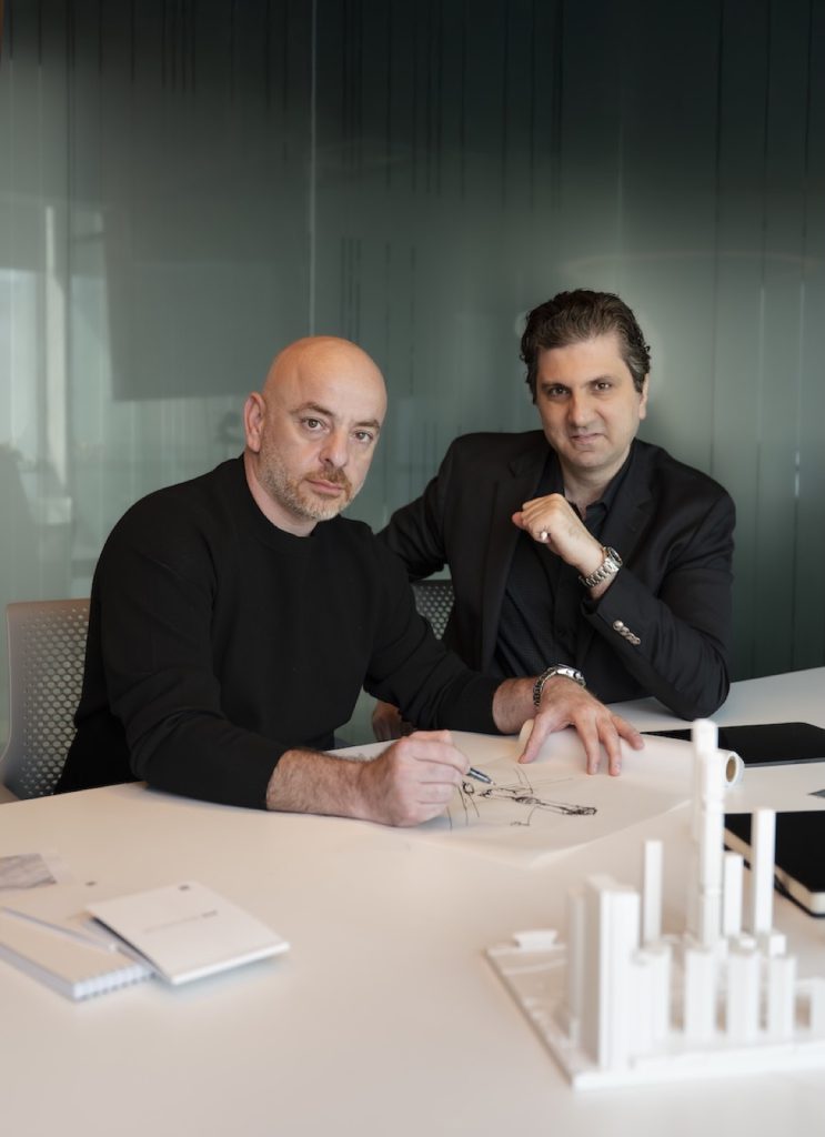 Two partners working at a table with architectural models