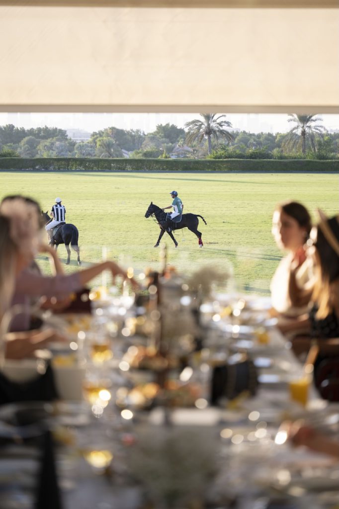 Guests watching polo from the dining terrace