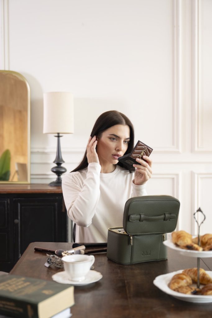 Model at a vanity table with skincare