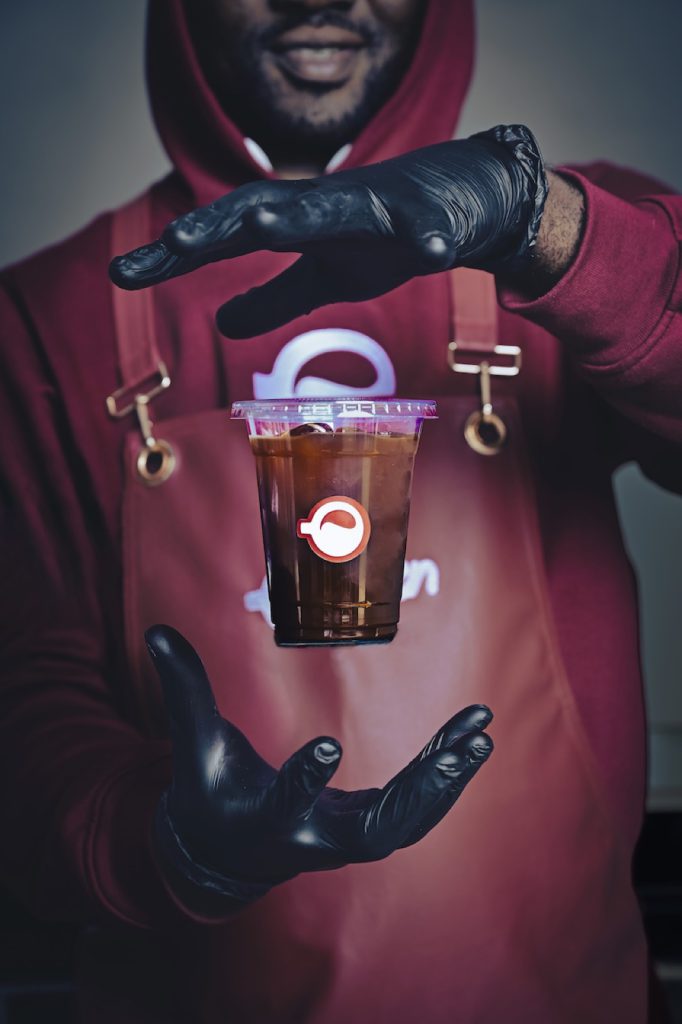 Barista with a levitating iced coffee