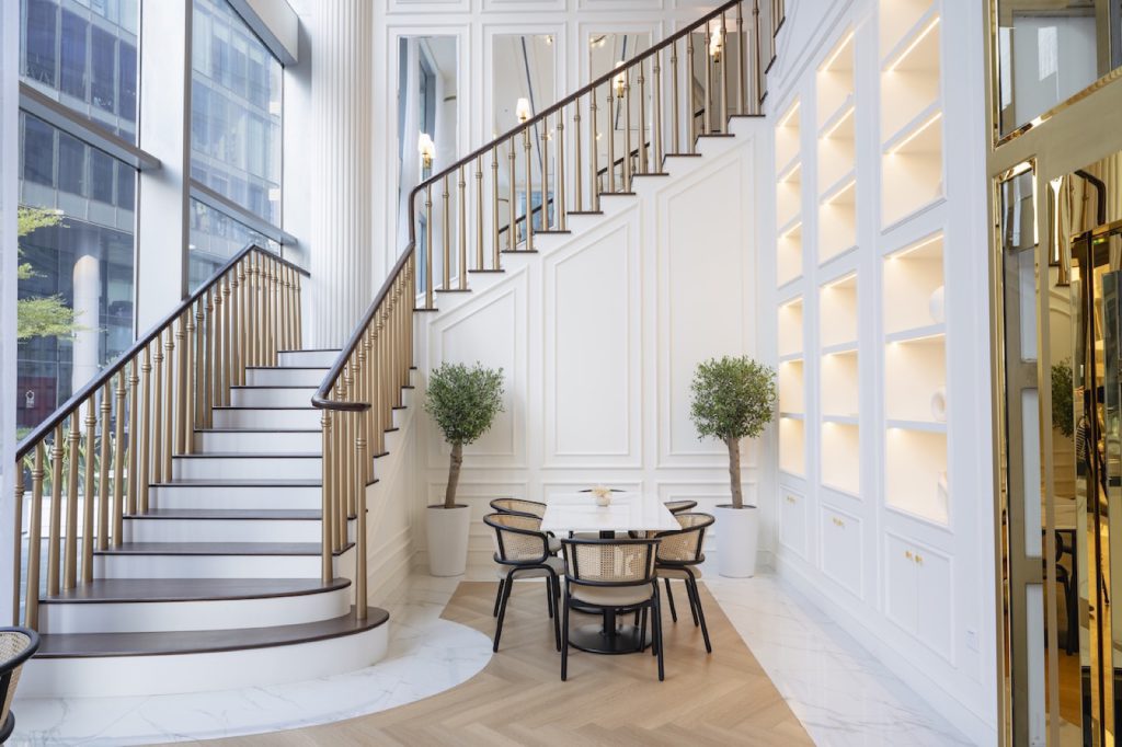 Dining area beneath a white staircase